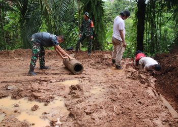 Meski diguyur Hujan, Satgas TMMD ke 123 dan Warga Tetap Semangat Pasang Buis Beton